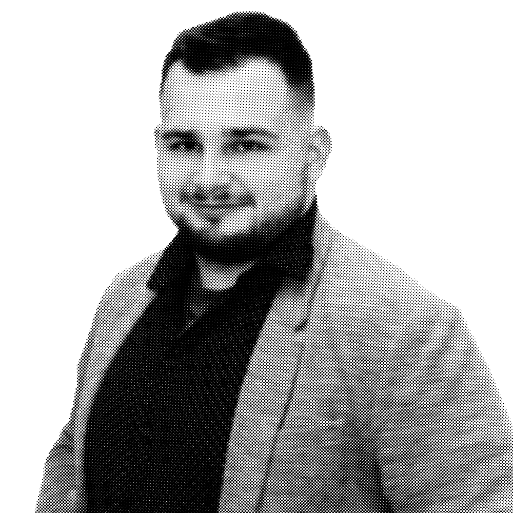 Sebastian Małek w szarym garniturze